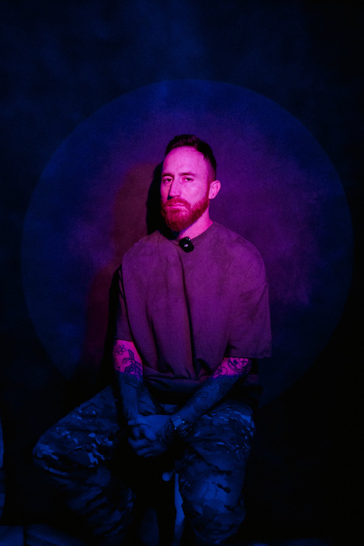 CALMA artist Carlos Alberto Lopez seated in purple and blue studio lighting
